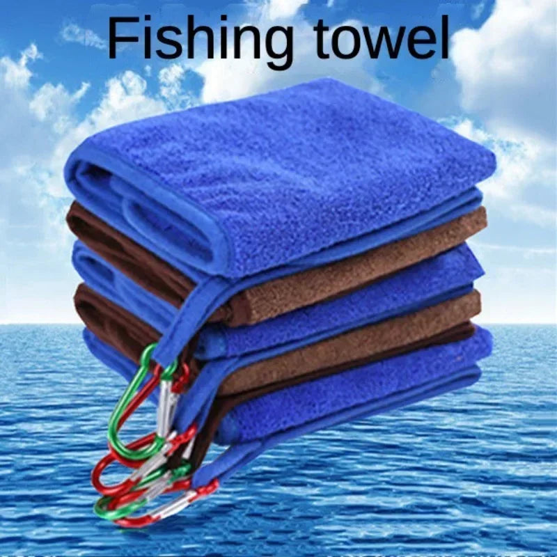 Stack of blue and brown fishing towels with a sky and water background