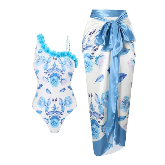 One-piece swimsuit with blue floral design and matching sarong on a white background