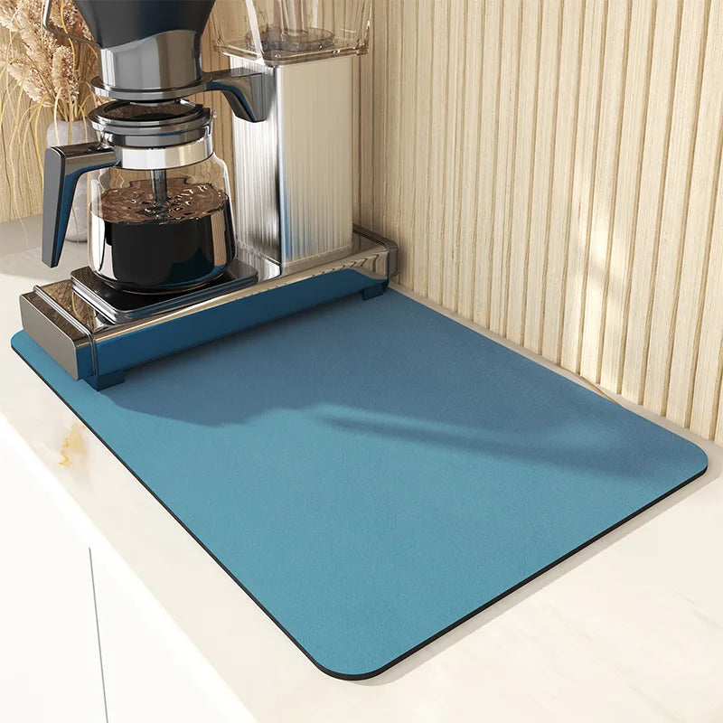 Blue mat protecting a kitchen counter from coffee spills, with a coffee maker on it.