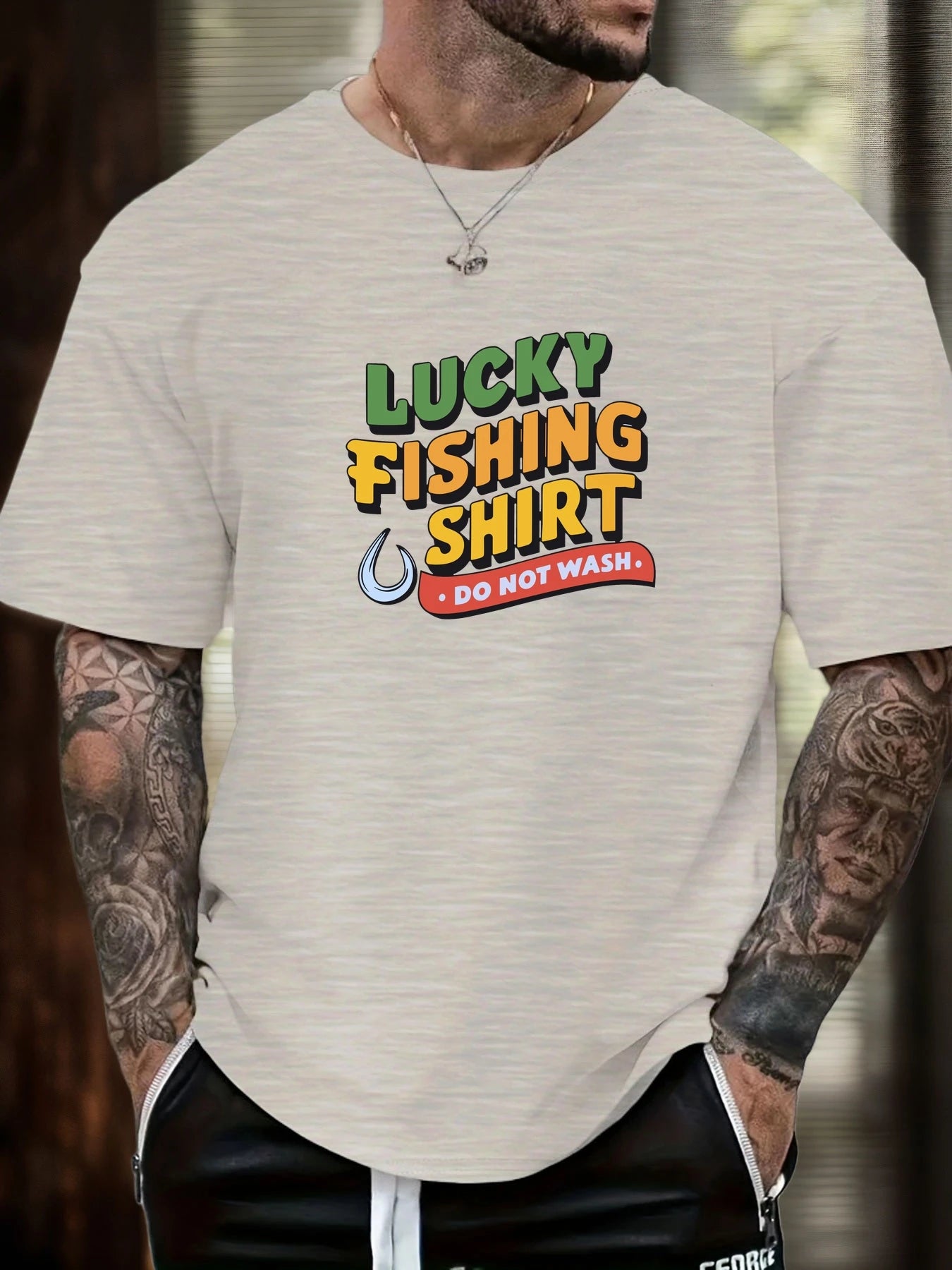Person wearing a beige t-shirt with a humorous fishing shirt graphic.
