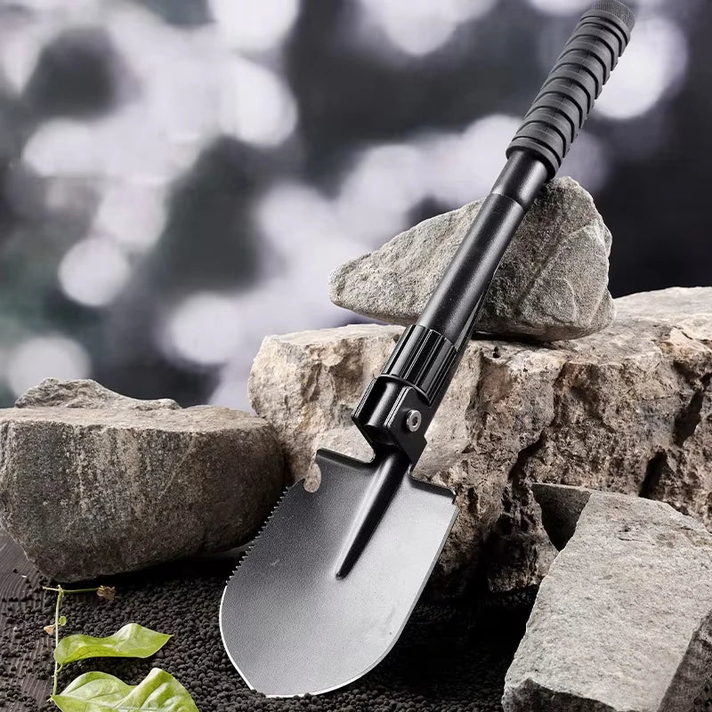 Folding shovel on a rock with a blurred natural background