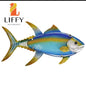 Handcrafted metal fish wall decor with stained glass elements for outdoor beach and poolside spaces.
