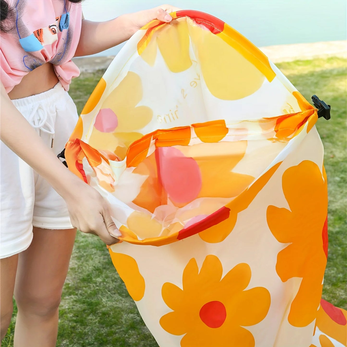 Colorful beach lounger with floral pattern held by a person outdoors