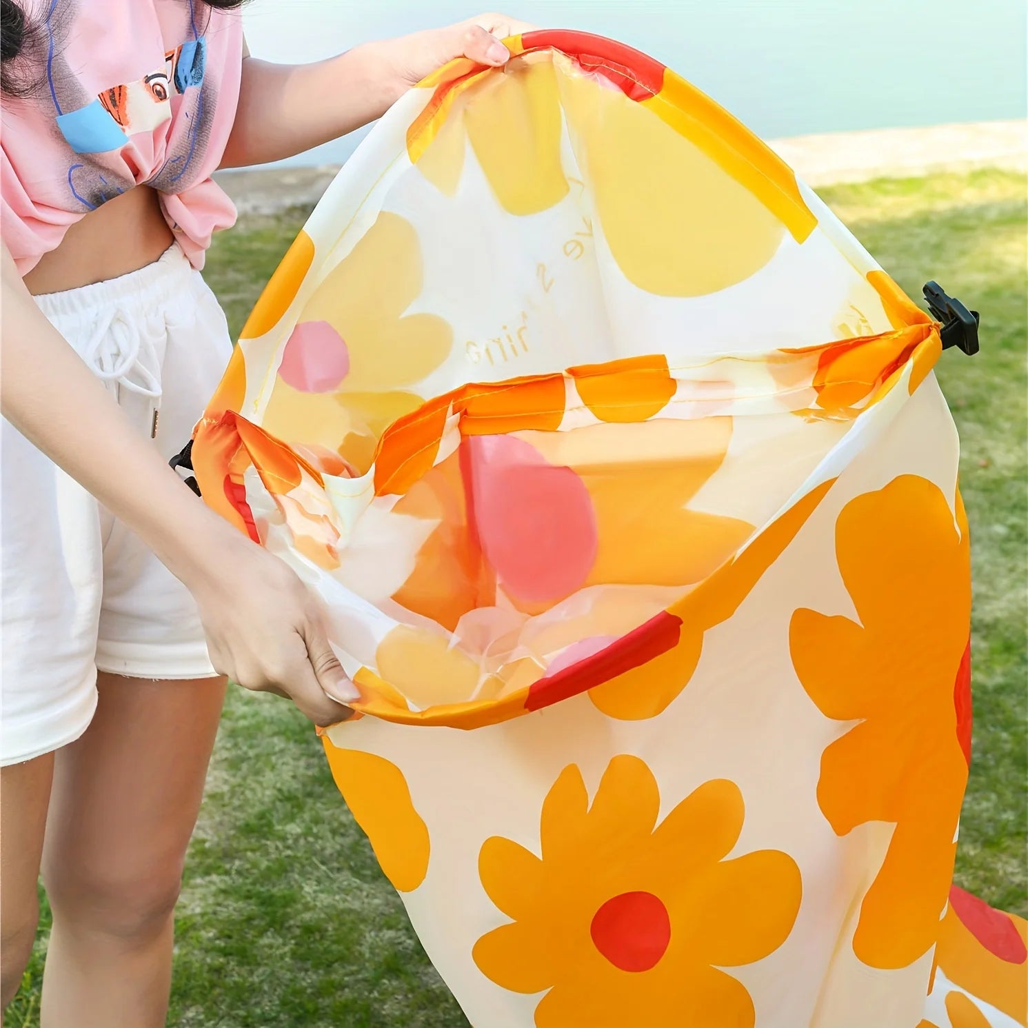 Colorful beach lounger with floral pattern held by a person outdoors