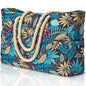 Tropical leaf patterned bag with rope handles on a white background