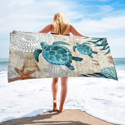 Person holding a beach towel with turtle design on a beach