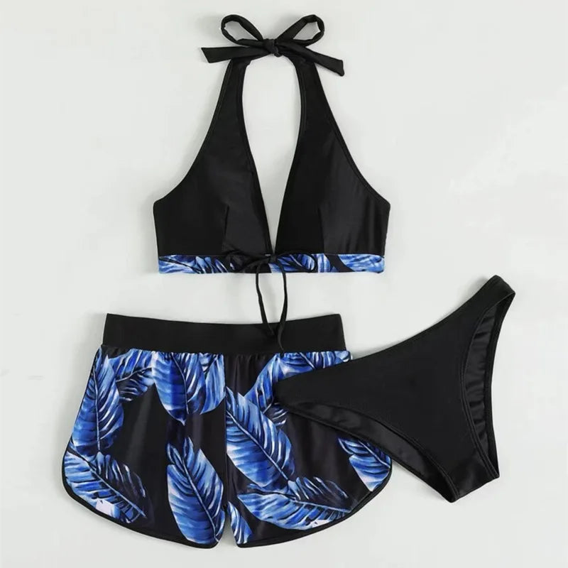 Black and blue leaf-patterned bikini set on a light gray background