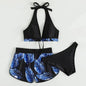 Black and blue leaf-patterned bikini set on a light gray background