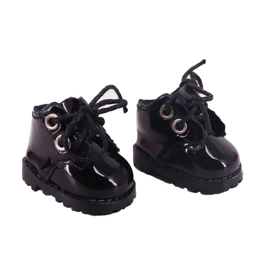 Pair of black shiny boots with laces on a white background