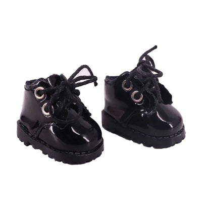 Pair of black shiny boots with laces on a white background