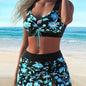 Woman wearing a black floral bikini set on a beach