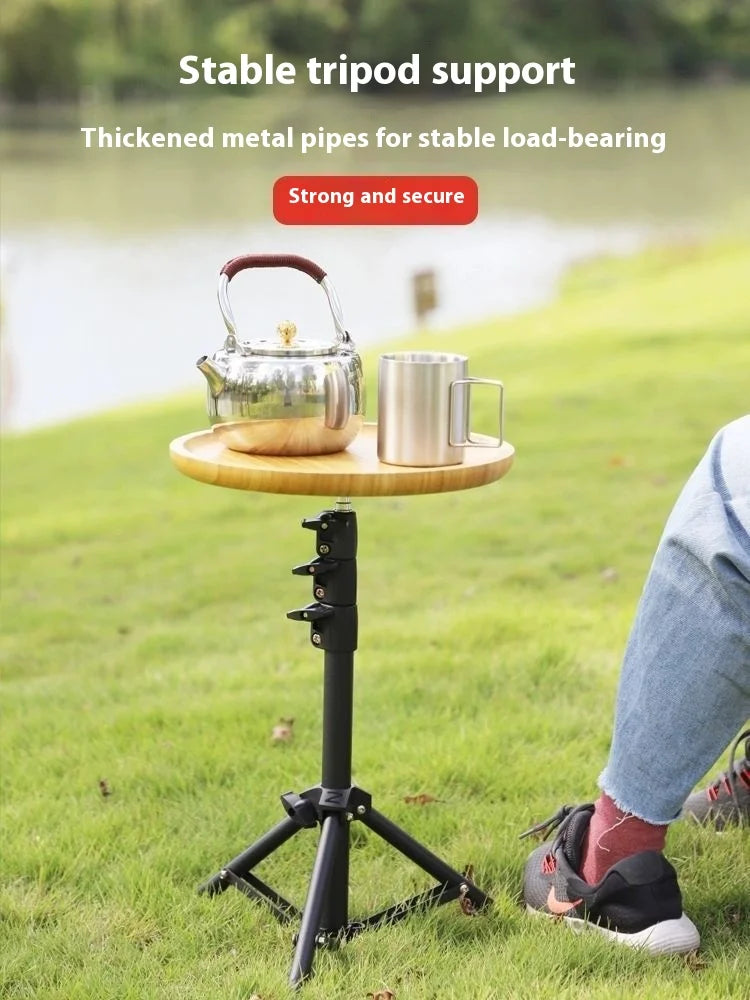 Tripod stand with a kettle and cup on a grassy area, emphasizing stability and security.