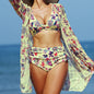 Woman wearing a colorful floral bikini and cover-up against a blue ocean background