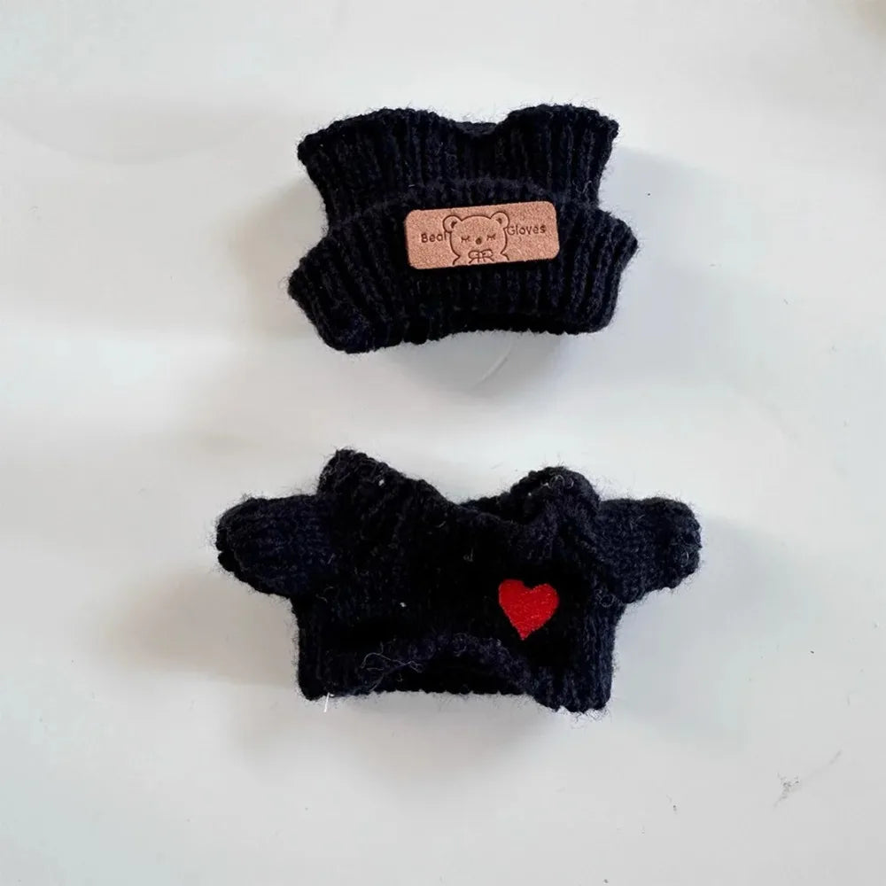 Two black knitted dog sweaters with a brand label on a white background