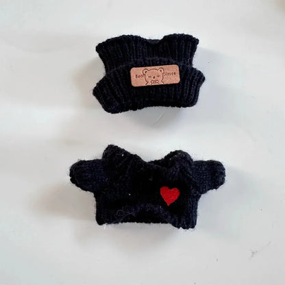 Two black knitted dog sweaters with a brand label on a white background