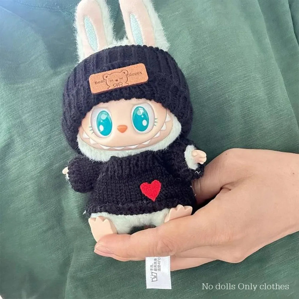 Toy figure wearing a black knit hat and sweater with a heart on a green background