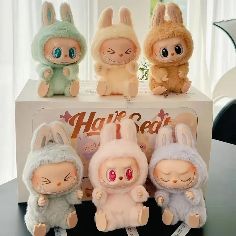 Six labubu toys with bunny ears and different colors on a stand with 'Haiieat' branding.