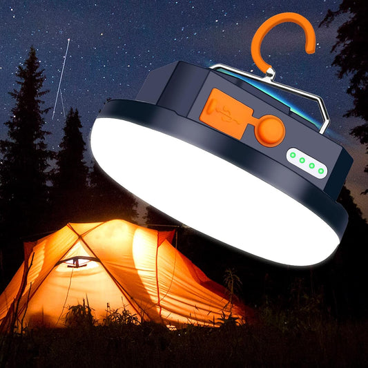 Camping light hanging above a tent with a starry night sky and trees in the background