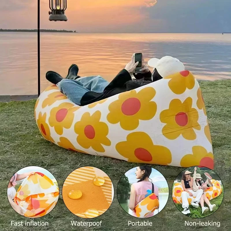 Inflatable floral-patterned air sofa with people using it by a lake at sunset.