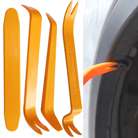 Set of orange car panel removal tools with a car door panel in the background.
