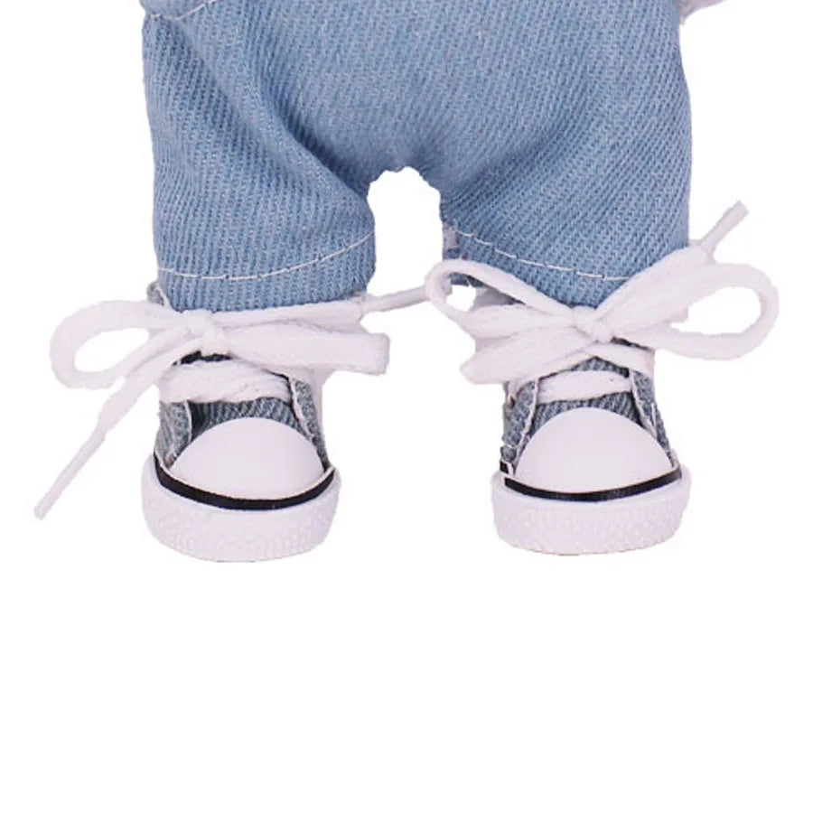 White sneakers with black soles worn by a person wearing blue jeans on a white background