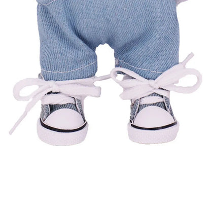 White sneakers with black soles worn by a person wearing blue jeans on a white background